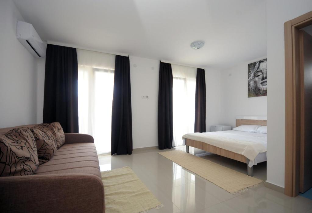 ein Wohnzimmer mit einem Bett und einem Sofa in der Unterkunft Apartments Vila Anastasia in Budva