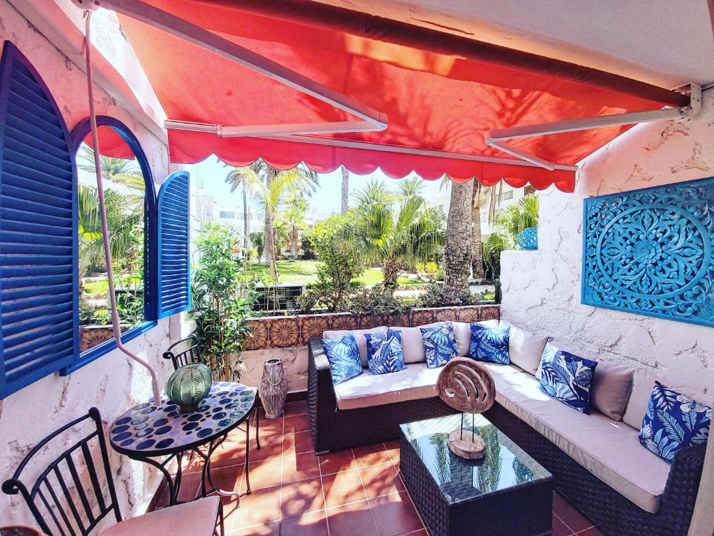 a patio with a couch and a table at Tropical garden view with pool in Costa Del Silencio