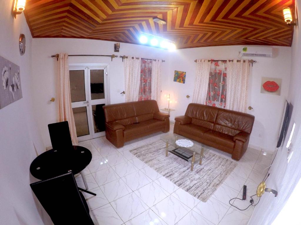 - un salon avec deux canapés en cuir et une télévision dans l'établissement TrierHouse, à Douala