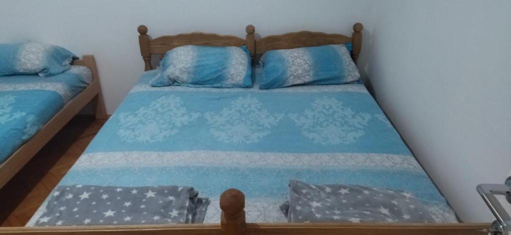 een slaapkamer met 2 bedden met blauwe lakens bij Apartman Lazovic in Arilje