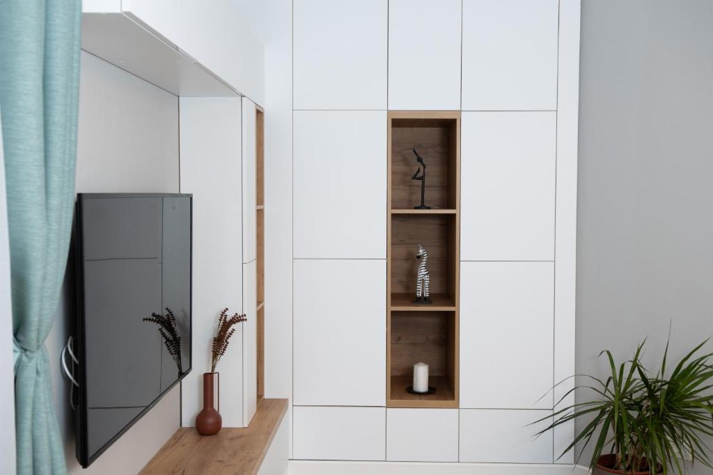 a bathroom with white walls and a mirror at Anise Apartment in Bucharest