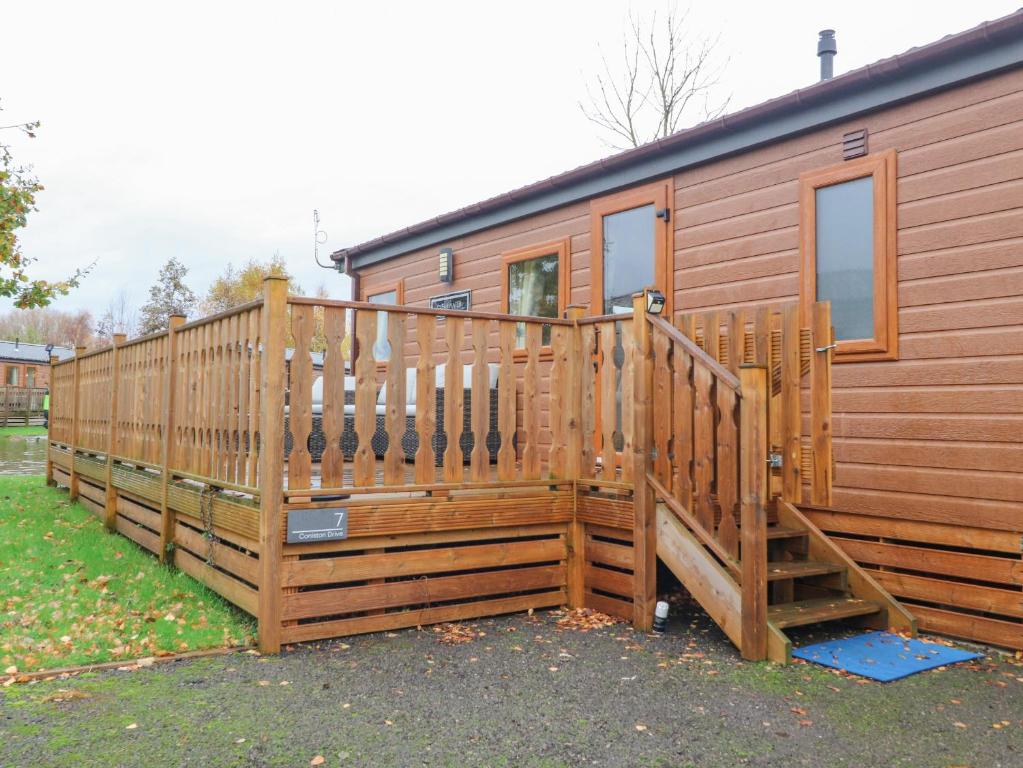 een houten hut met een groot houten terras bij Fountain View in Carnforth