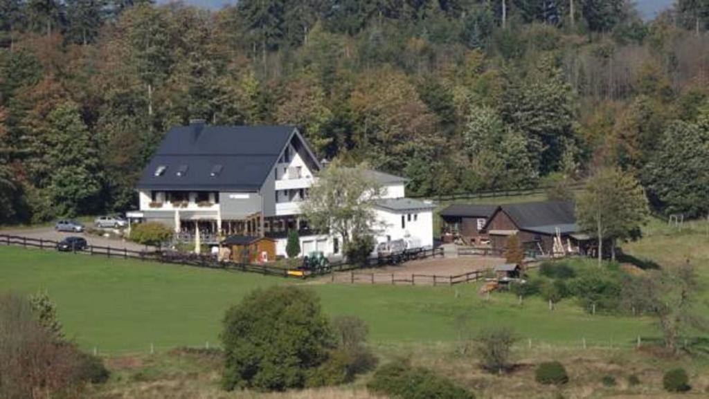 eine Luftansicht eines großen Hauses auf einem Feld in der Unterkunft Ginsberger Heide in Hilchenbach