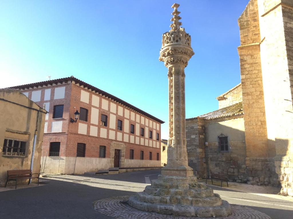 un poste en medio de una calle con un edificio en Hotel Rural En El Camino en Boadilla del Camino