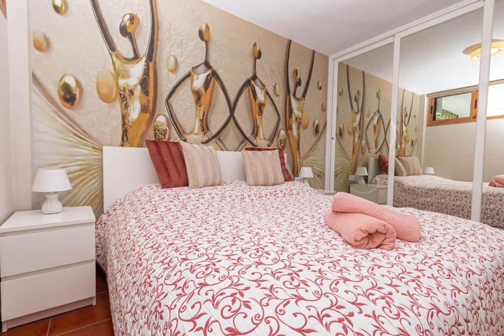 a bedroom with a large bed with a large headboard at Golden Sunny View Apartment in Puerto Rico de Gran Canaria