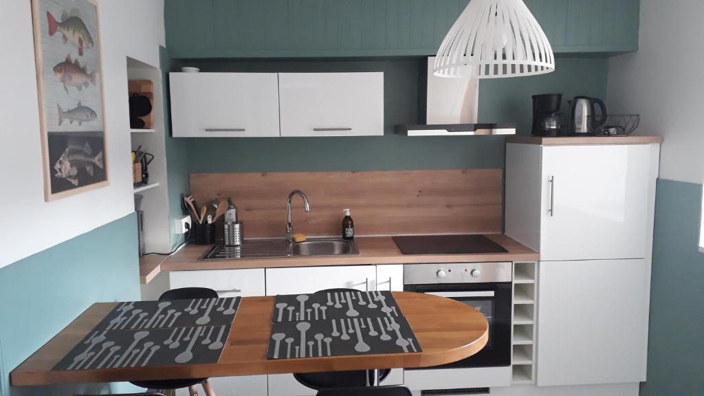 eine Küche mit einem Holztisch und einem Waschbecken in der Unterkunft Appartement, port de Binic in Binic