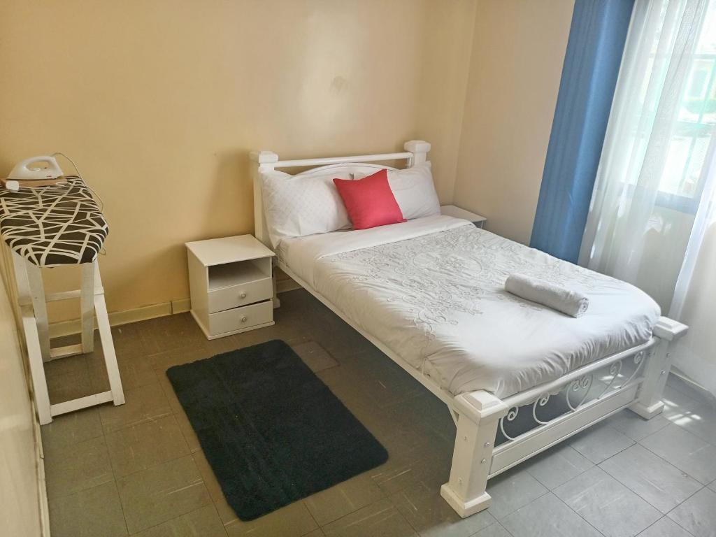 niewielka sypialnia z łóżkiem i stołkiem w obiekcie GCurtway Homes Nyayo 3 bedroom w mieście Nairobi