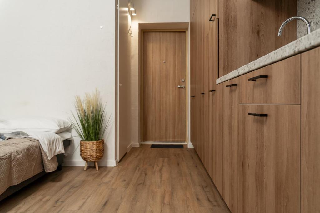 een slaapkamer met een bed en een houten kast bij Air Apartment 310 in Vilnius