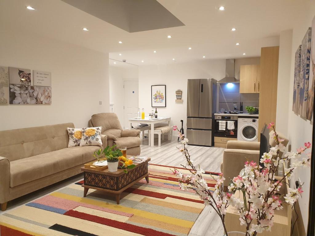 ein Wohnzimmer mit einem Sofa und einem Tisch in der Unterkunft New - Spacious London 1 bedroom king bed apartment in quiet street near parks 1072gar in London