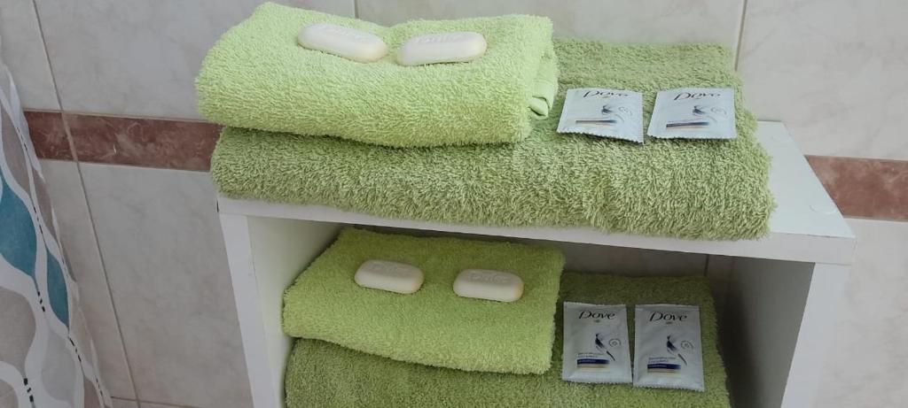 a bathroom with green towels on a shelf at Departamento ANGOSTURA in General Alvear