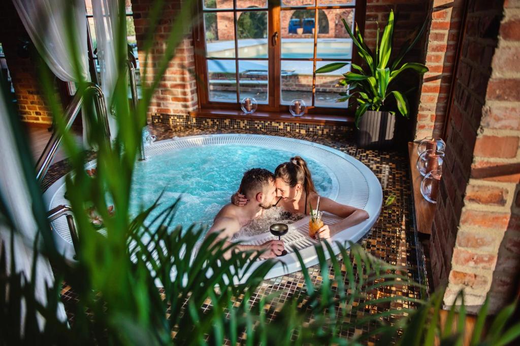 a man and a woman in a bath tub at Żabi Dwór - HOTEL - RESTAURACJA - SPA in Zielona Góra