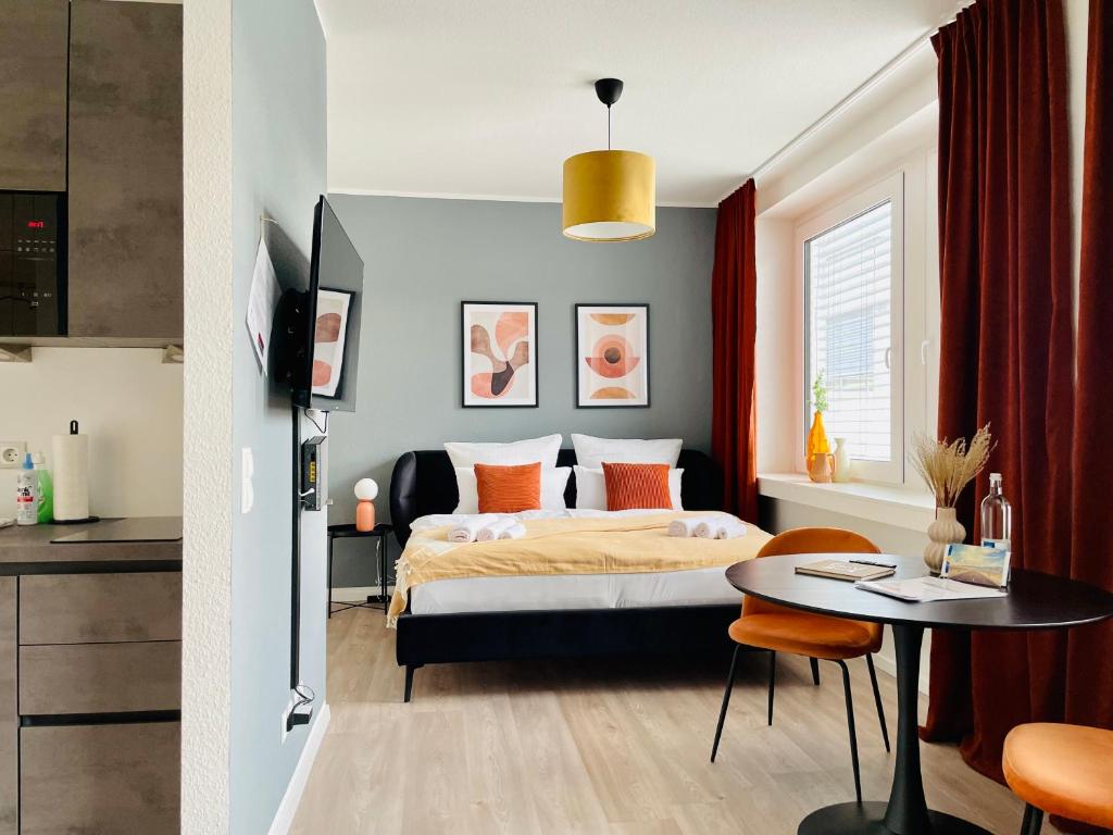 a bedroom with a bed and a table in a room at Klassen Stay - Exklusives Apartment am HBF - Küche, Netflix, Kingsizebett in Koblenz