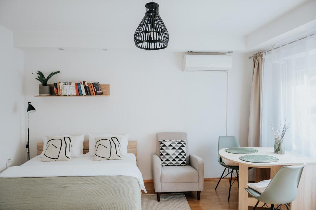 ein Schlafzimmer mit einem Bett, einem Tisch und einem Stuhl in der Unterkunft Soul Apartments in Izola