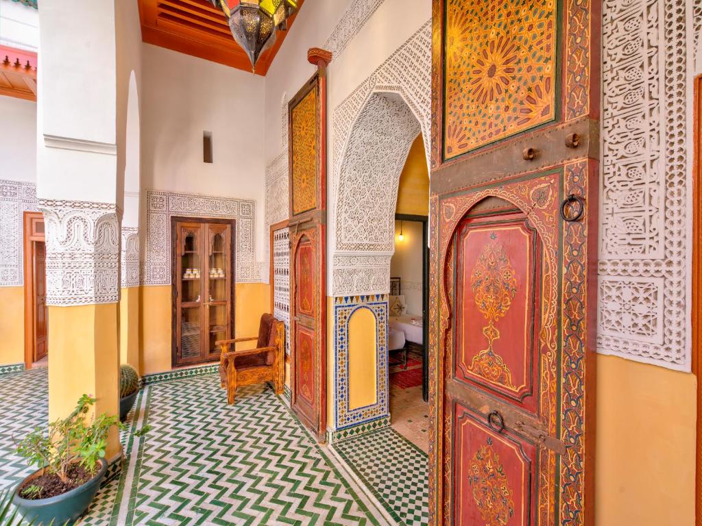 een toegang tot een kamer met een houten deur bij Palais Tinmel Marrakech in Marrakesh