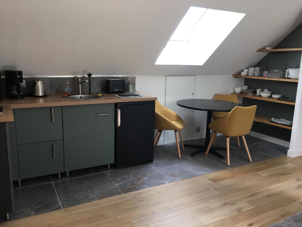 a kitchen with a sink and a table with chairs at Appartement à l'étage de notre maison in Rochecorbon