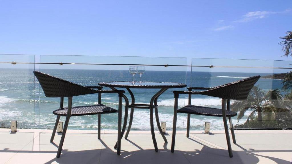 揚巴的住宿－Bluefish，一张桌子和椅子,享有海景