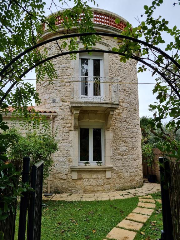 ein Steinhaus mit Balkon darüber in der Unterkunft Moulin Vieux in Saint-Palais-sur-Mer
