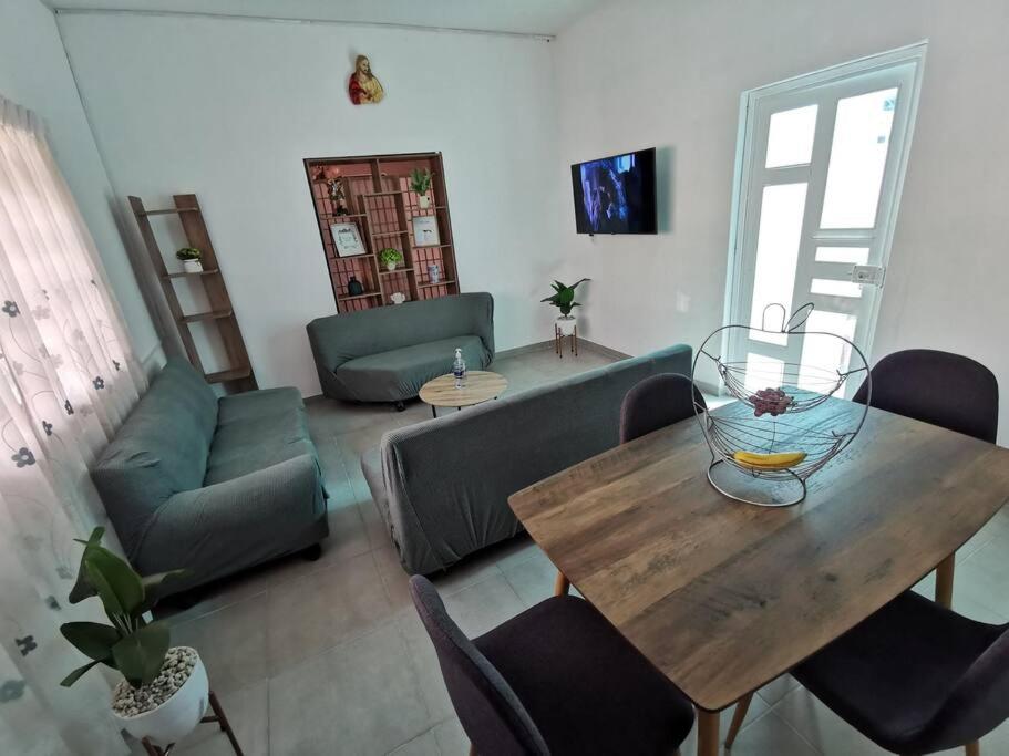 sala de estar con mesa y sofá en Acogedor departamento en Santa Rosa