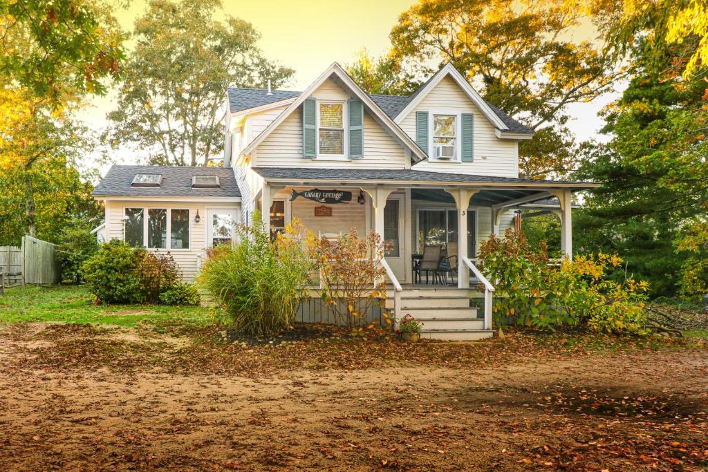 ein kleines weißes Haus mit einer Veranda in der Unterkunft Canary Cottage in Oak Bluffs