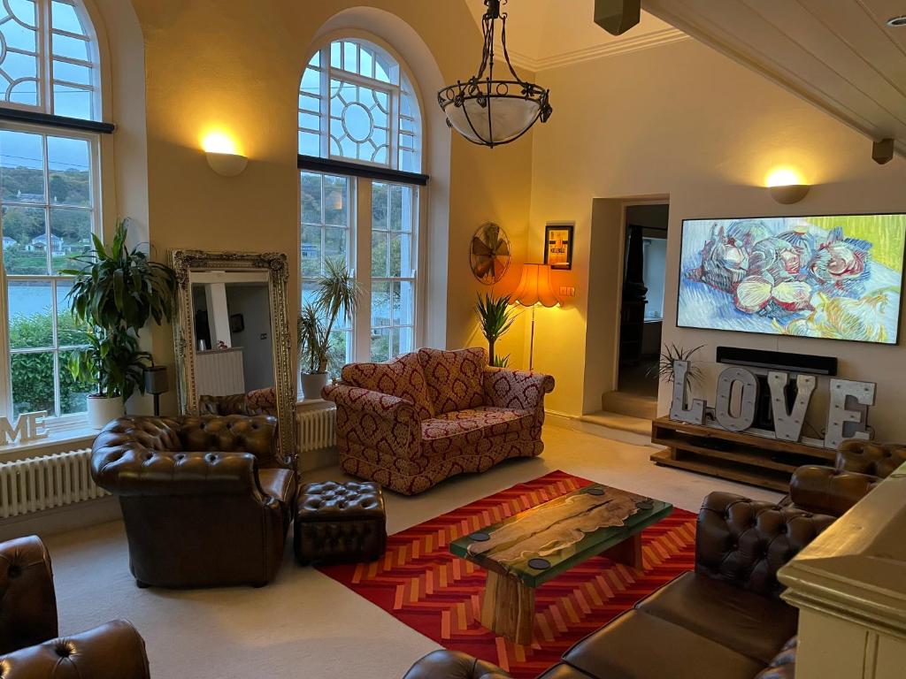 a living room with couches and a flat screen tv at The Old Court House & Jail in Menai Bridge