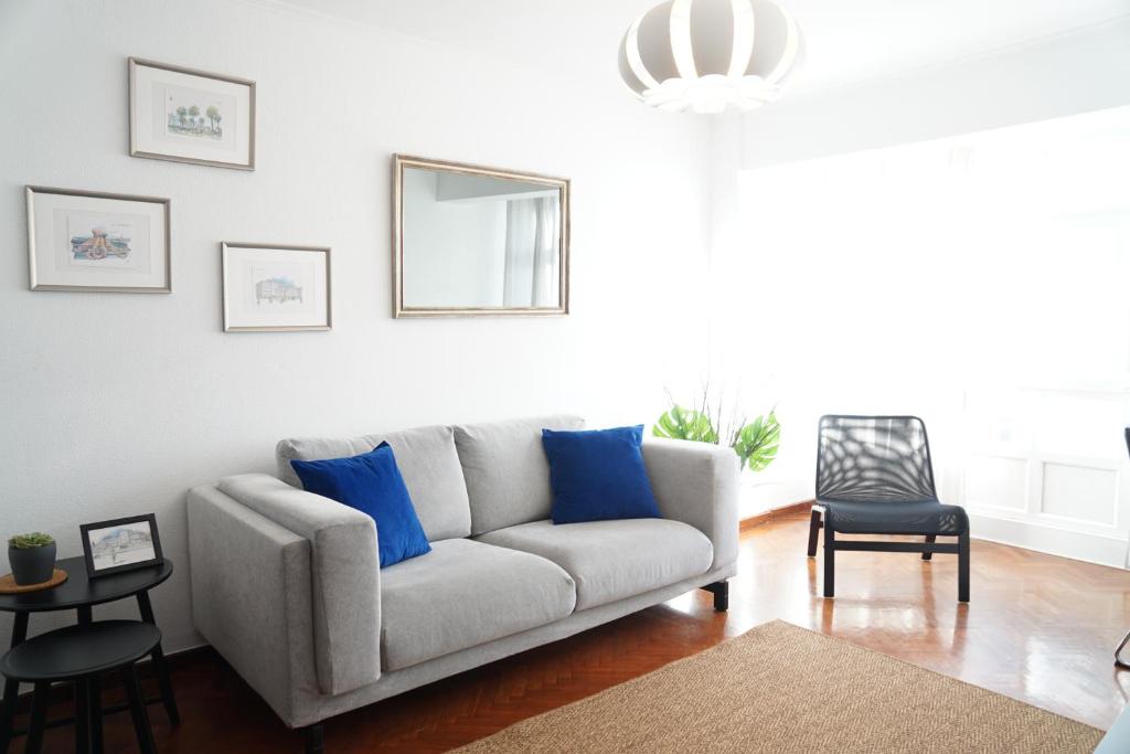 een woonkamer met een bank met blauwe kussens bij Amazing Location CORUÑA DOWNTOWN in A Coruña