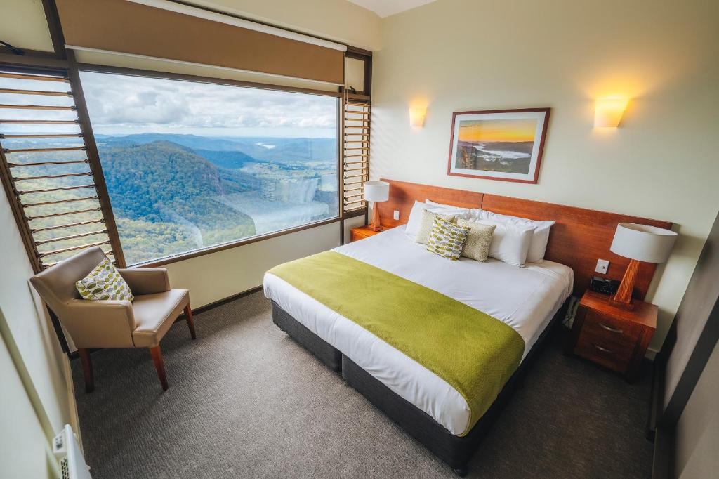 a hotel room with a bed and a large window at Binna Burra Sky Lodges in Beechmont