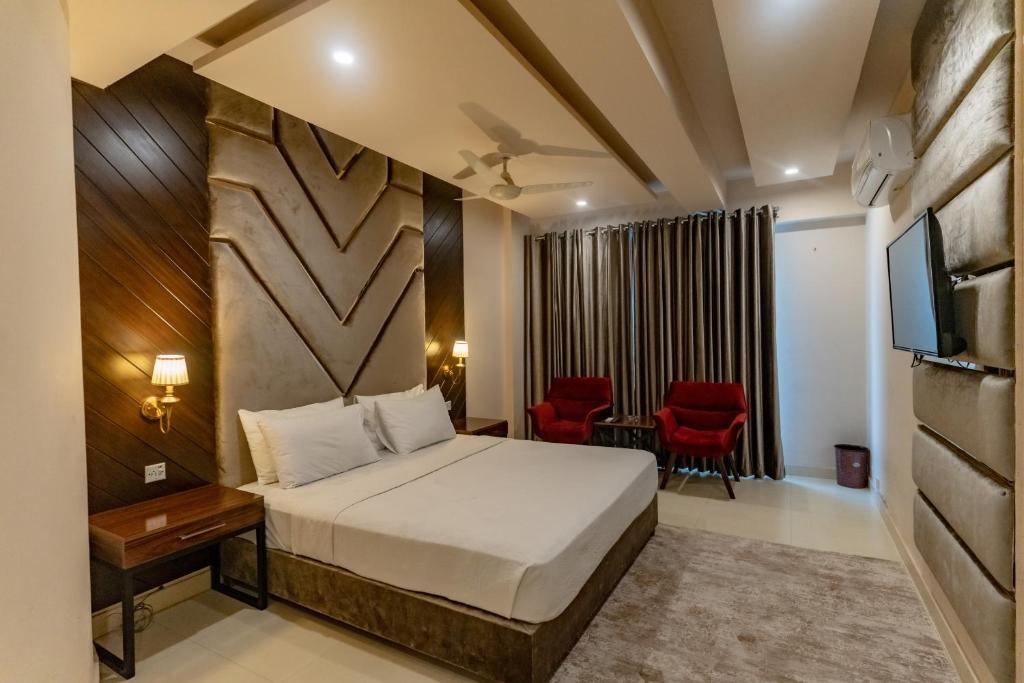 a hotel room with a bed and a television at Shelton Guest House in Islamabad