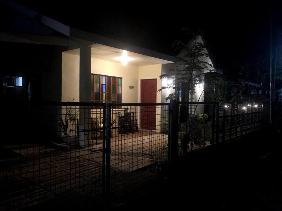 una casa di notte con una recinzione di fronte di 1 BR Staycation near Kidapawan City a Makilala