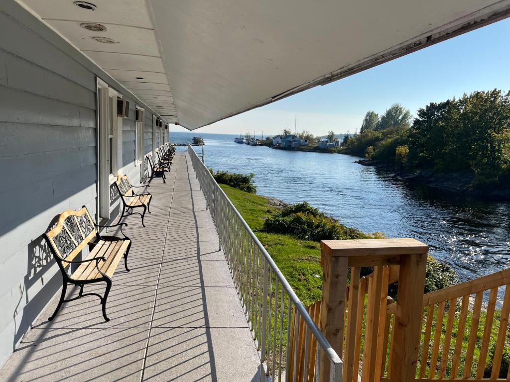 a balcony with benches looking out over a river at Old Mill Motel in Blind River