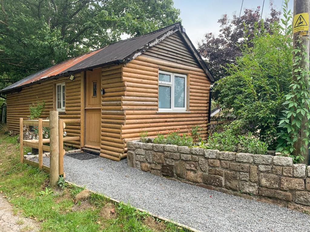 a small wooden cabin with a stone wall at Uk41510 - The Cabin in Boyton