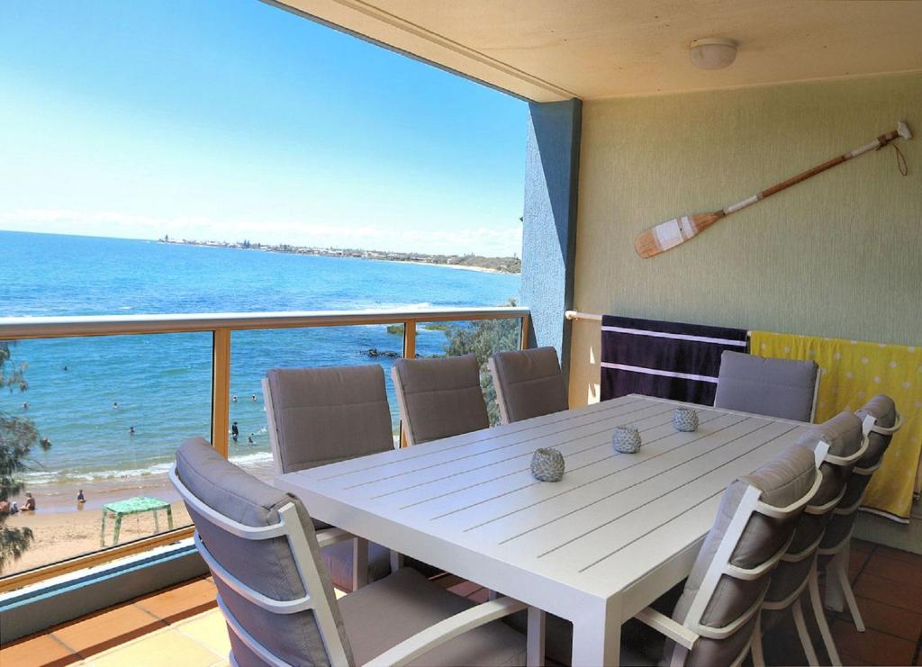 a dining room with a table and a view of the beach at Pacific Links 3a in Bargara
