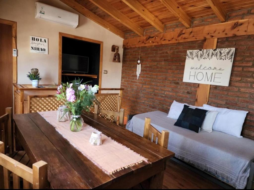 Un dormitorio con una cama y una mesa con flores. en Malargue house II. en Malargüe