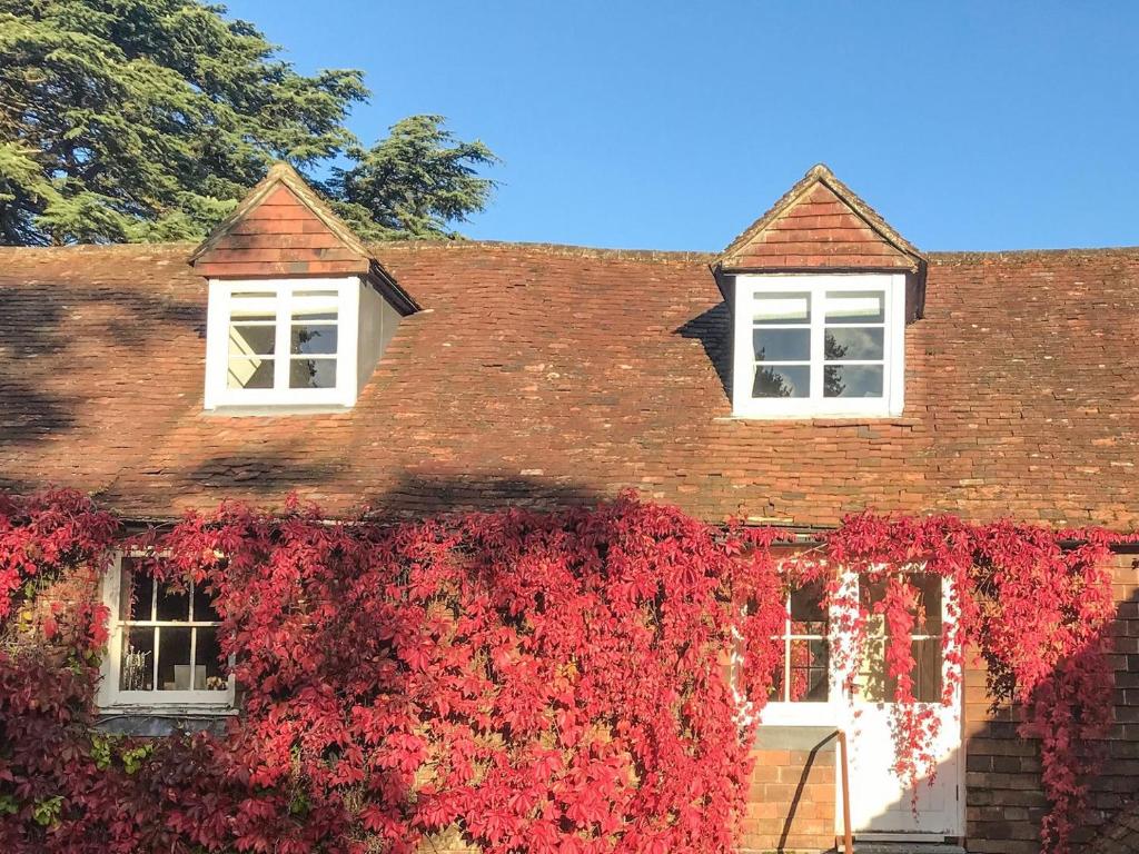 a brick house with red ivy growing on it at Old Rectory Loft in Fernhurst