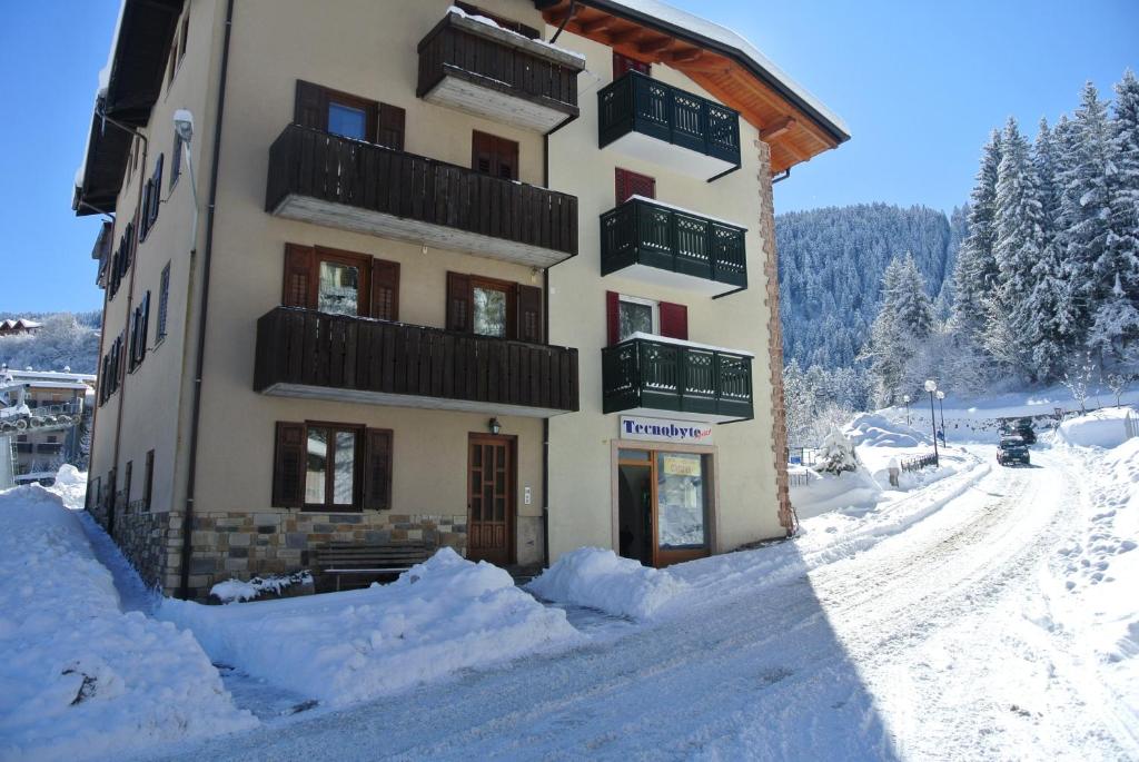 a building covered in snow with snow around it at Casa Perli in Andalo