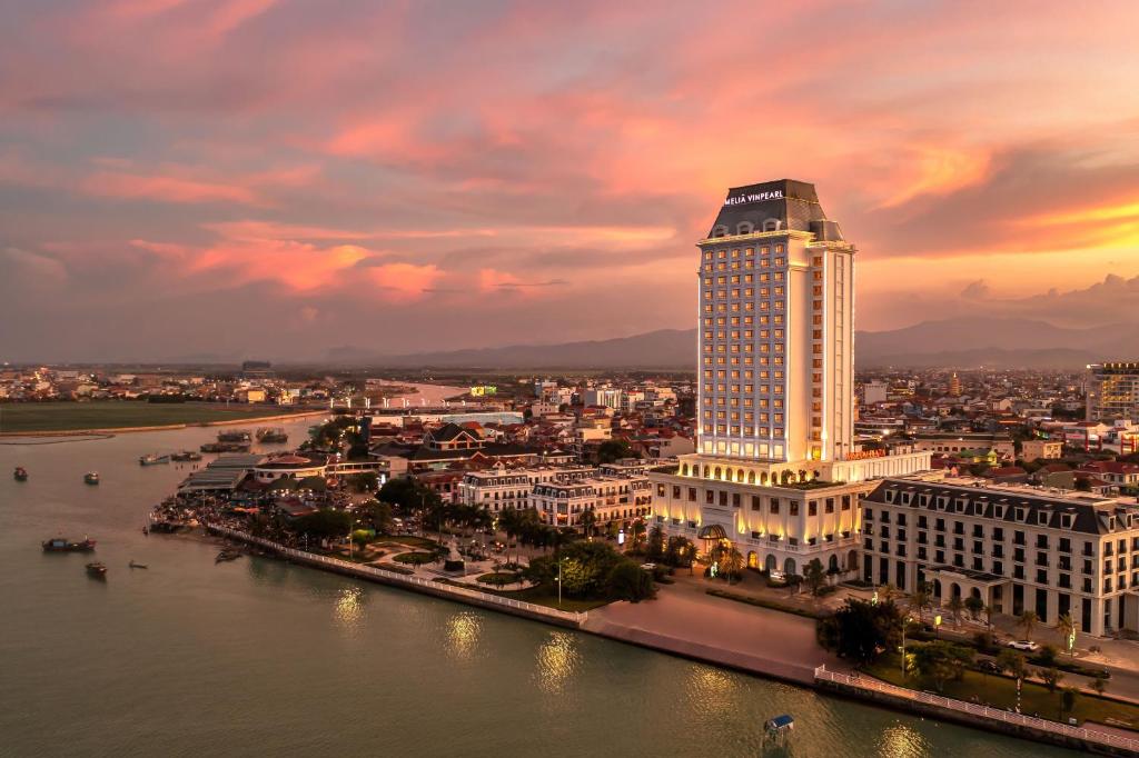 una ciudad con un edificio alto junto a un río en Melia Vinpearl Quang Binh, en Dong Hoi