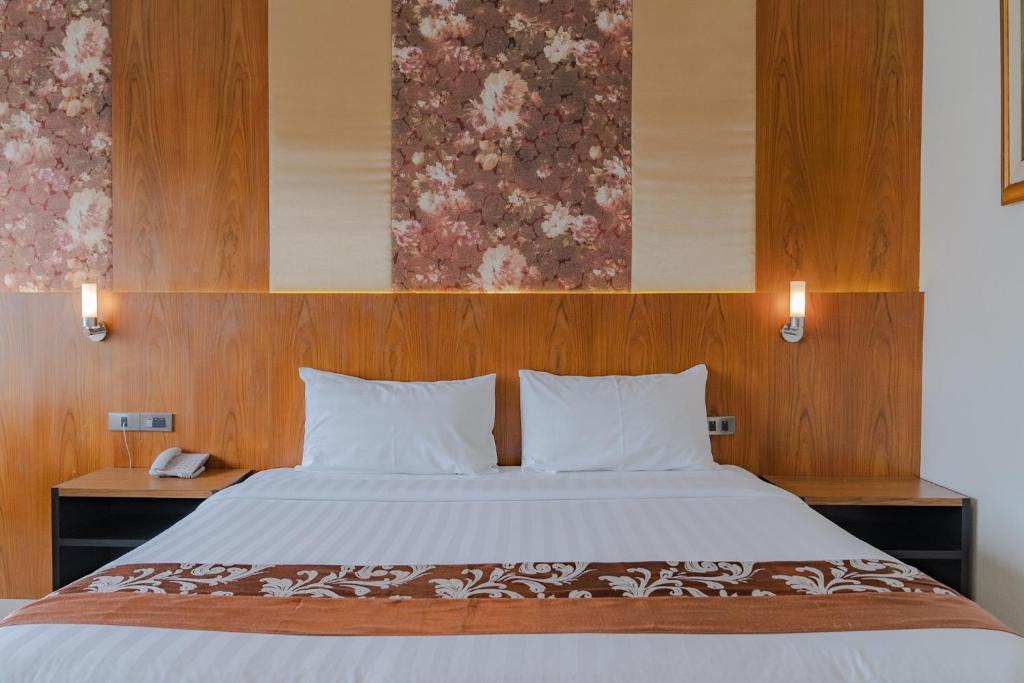 a bedroom with a large bed with wood paneling at Forum Park Hotel in Bangkok