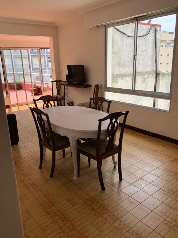 comedor con mesa, sillas y ventana en Check and Home - Sacoa - 6 huéspedes con vista al mar, terraza privada y parrilla en Mar del Plata