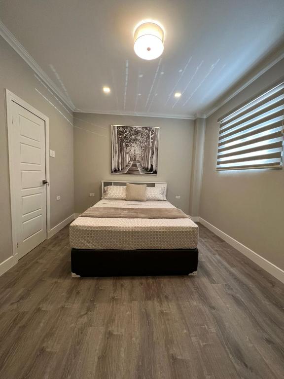 a bedroom with a bed in a room with wooden floors at SHAK Condos- Luxury, Functionality and Comfort in Saint Helena