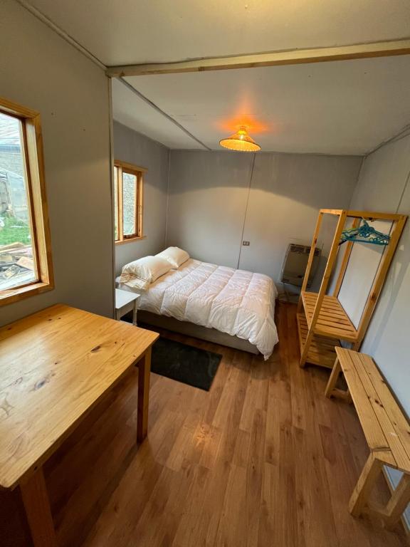 um quarto com uma cama e uma mesa de madeira em Isla Yu Patagonia 2 em Puerto Natales