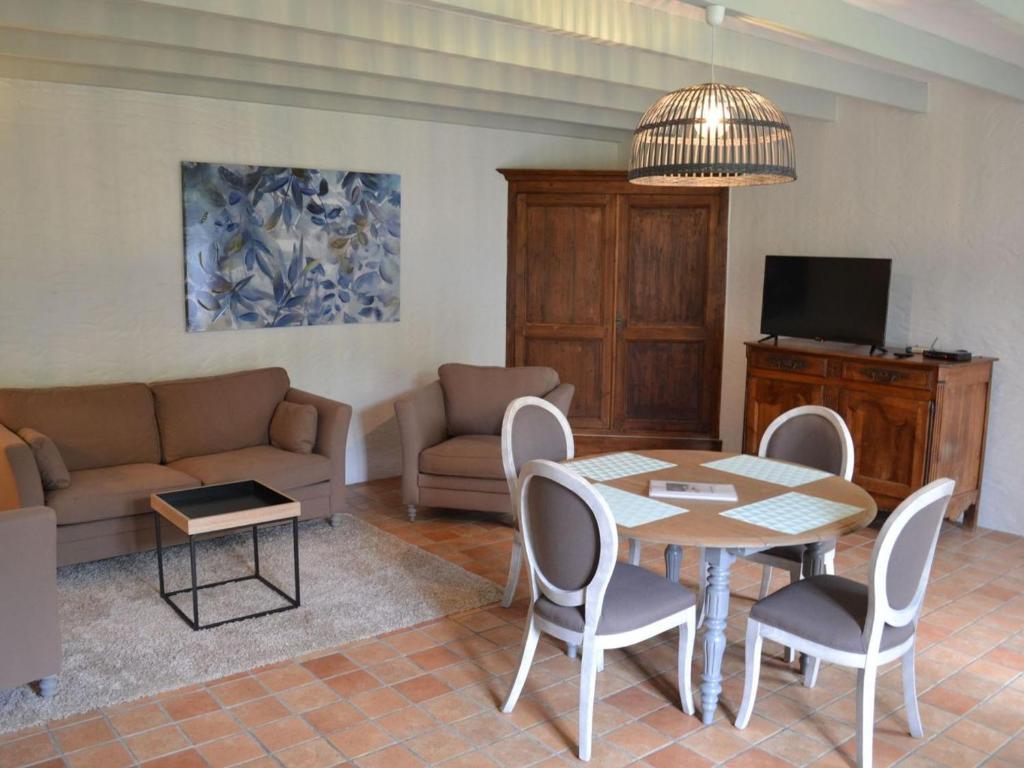 salon ze stołem, krzesłami i kanapą w obiekcie Gîte spacieux avec jardin, piscine, cheminée, et équipements bébé au cœur des vignes du Cognac - FR-1-653-59 w mieście Lignières-Sonneville