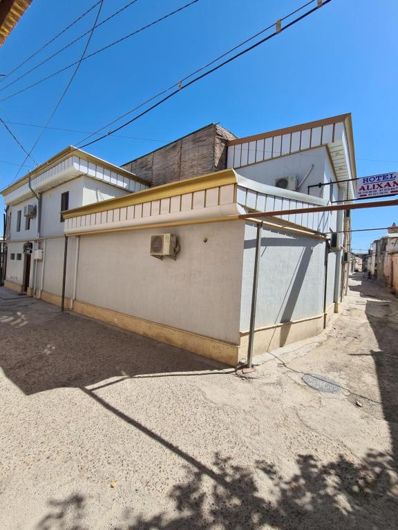 un edificio bianco sul lato di una strada di ALIXAN Hotel a Bukhara