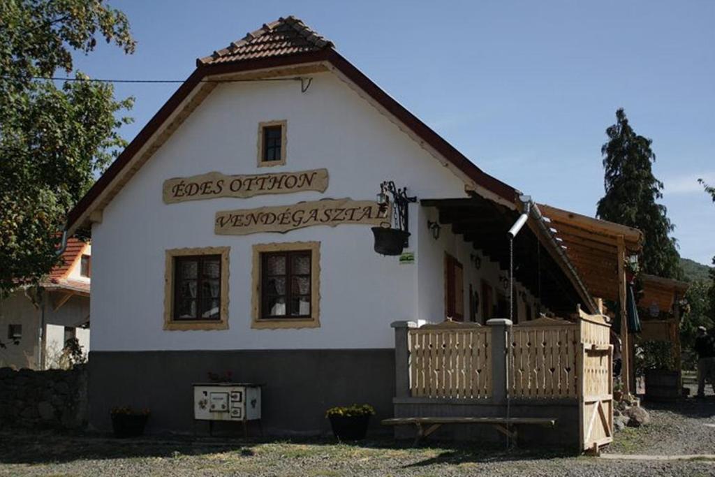 Ein weißes Haus mit einem Schild, das die Meinung der Hunde liest in der Unterkunft Édes Otthon Vendégház in Nagybörzsöny