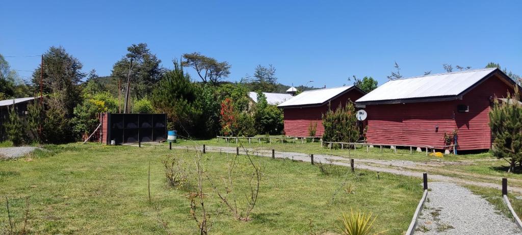 a group of red barns in a field at Cabañas el Rombo in Puerto Montt
