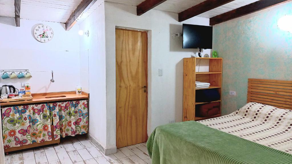 1 dormitorio con 1 cama y vestidor con TV en Dona Monica en Ituzaingó