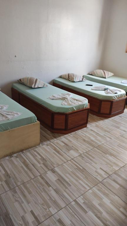 3 camas en una habitación con suelo de madera en Hotel popular são Matheus, en São Paulo