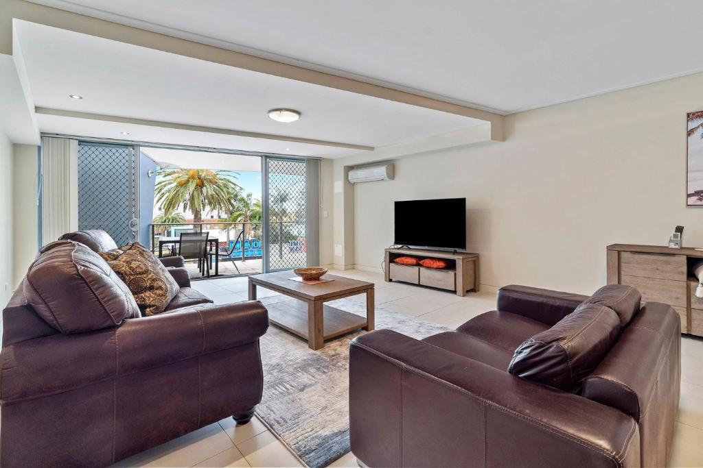 Sala de estar con 2 sofás y TV en Coast on Coral Luxury Apartment Unit 15, en The Entrance