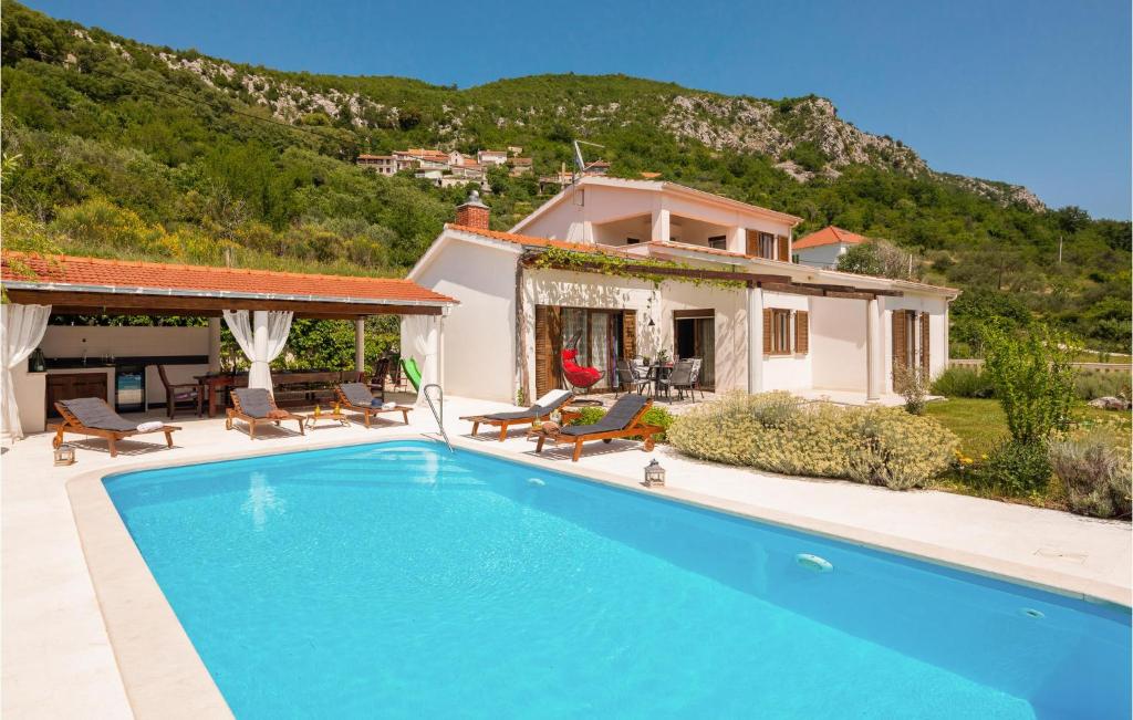 Villa con piscina frente a una casa en Lovely Home In Blato Na Cetini With Kitchen en Blato na Cetini