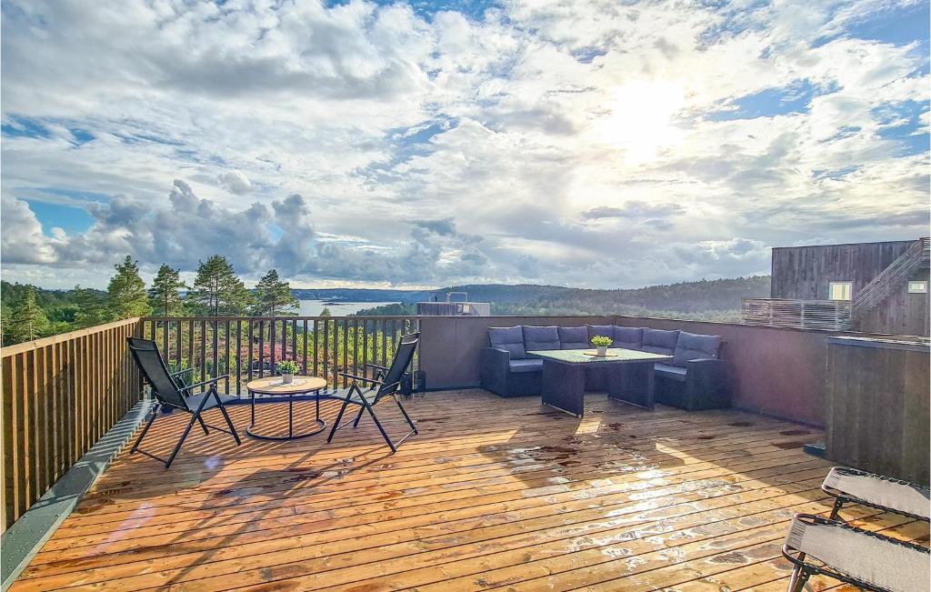a deck with chairs and a table on a balcony at 3 Bedroom Cozy Home In Søndeled in Søndeled