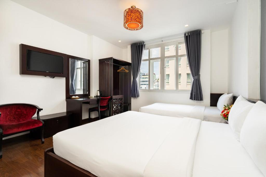 Habitación de hotel con 2 camas y TV en A&A Toronto Hotel, en Ho Chi Minh