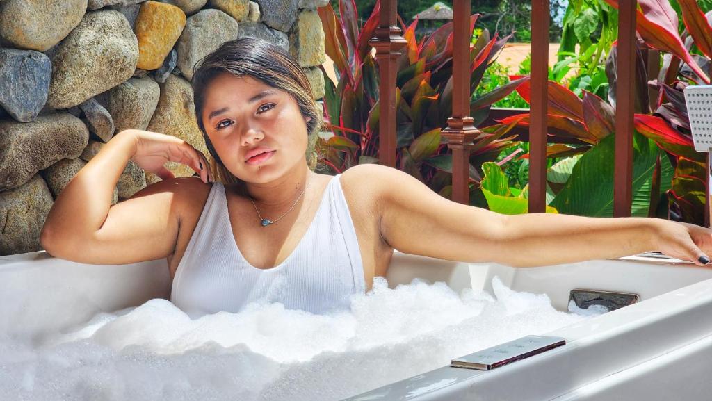 a woman sitting in a bath tub with snow at Rio Verde by Villa Alejandro in Boquete